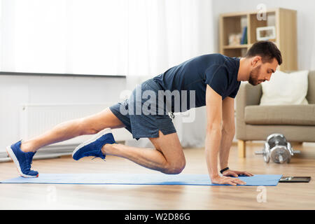man doing running plank exercise at home Stock Photo