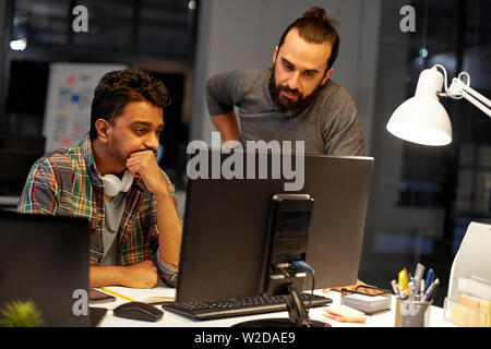 creative team with computer working late at office Stock Photo