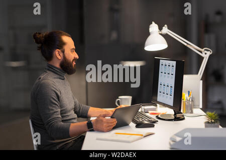 creative man with computer working at night office Stock Photo