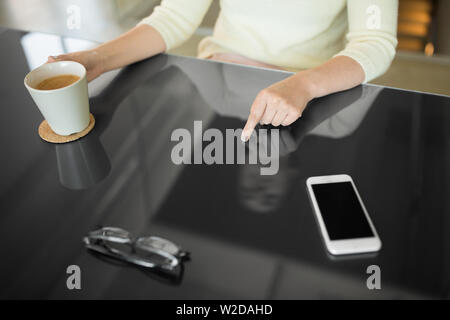 woman with coffee using black interactive panel Stock Photo