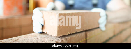 Male smiling builder puts make brickwork Stock Photo