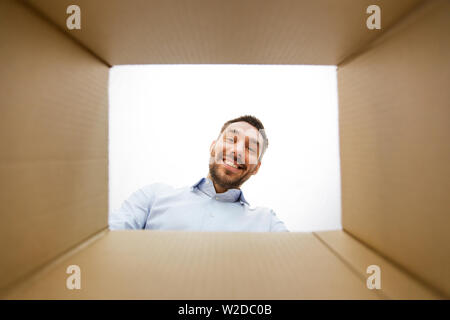 man looking into open parcel box Stock Photo