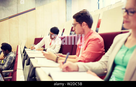 group of students with notebooks in lecture hall Stock Photo