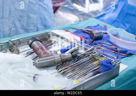 Drills and drillparts with blood in a tray during a Hip Replacement Operation in an NHS Hospital. Stock Photo