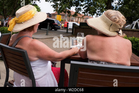 Two middle aged women enjoying a glass of wine in the English summer Stock Photo