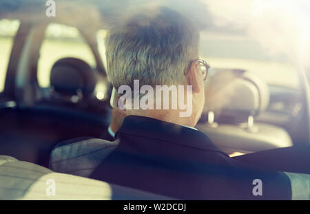 senior businessman calling on smartphone in car Stock Photo