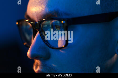 close up of hacker in glasses looking at screen Stock Photo