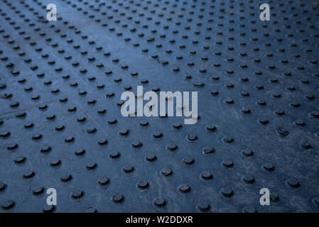 Black, textured ground protection matting for heavy vehicles on slippery,soft ground. Stock Photo