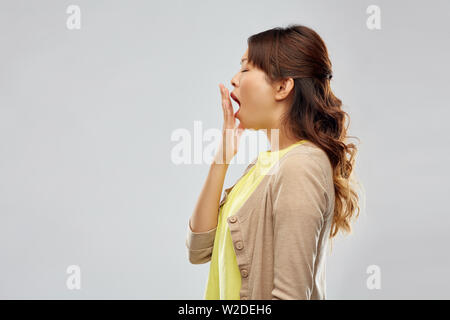 sleepy asian woman yawning Stock Photo