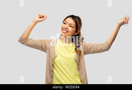 happy asian woman dancing over grey background Stock Photo