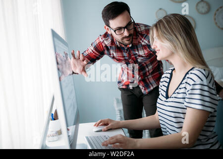 Young attractive designers working on project together Stock Photo