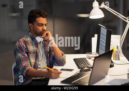 creative man with laptop working at night office Stock Photo