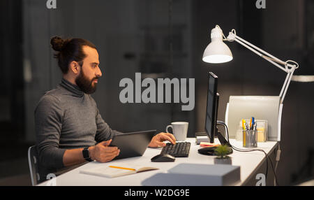creative man with computer working at night office Stock Photo