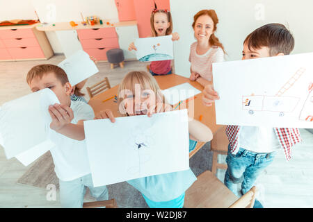 Top view of happy positive children with drawings Stock Photo