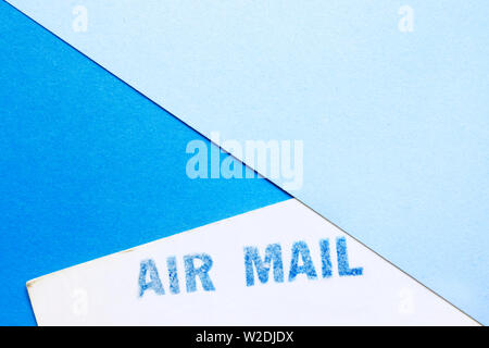Blue air mail stamp on a white postcard ,blue paper background , Stock Photo