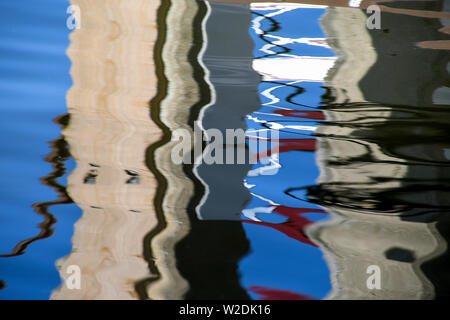 concrete dock piling in abstract wavy water reflection pattern Stock Photo