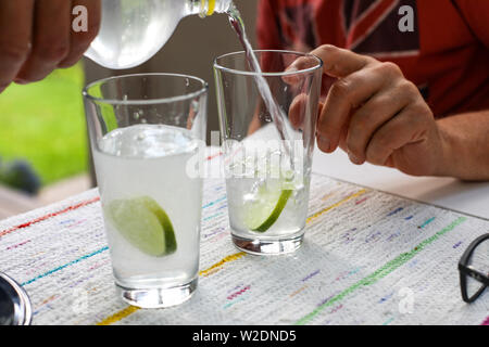 Pouring tonic water on gin and lemon Stock Photo