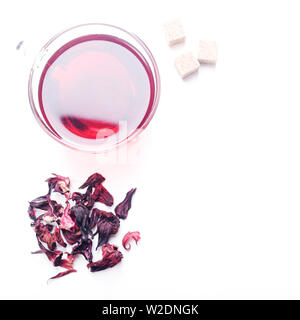 Top view of Hibiscus Tea cup with petals and sugar cubes aside on white background Stock Photo