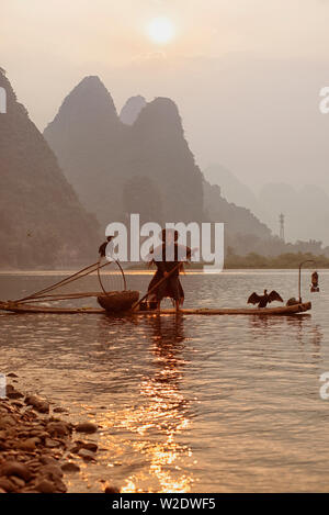 GUILIN, CHINA – September 19, 2017:  Sailing peacefully across a river, Guilin cormorant fishermen set out on the river Li during the early morning. Stock Photo