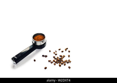Scattered coffee beans around the coffee horn with ground coffee. Stock Photo