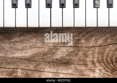 black and white keyboard musical electronic piano on textured wooden table top view keyboard on top of image Stock Photo