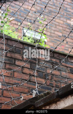 Barbed wire fencing protecting a building Stock Photo - Alamy