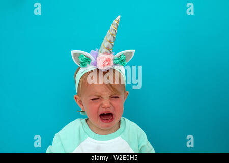 Crying baby in unicorn costume Stock Photo