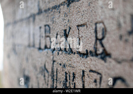 A piece of very old graffiti in Oxford - ether into a stone wall reads the word Baker. Stock Photo