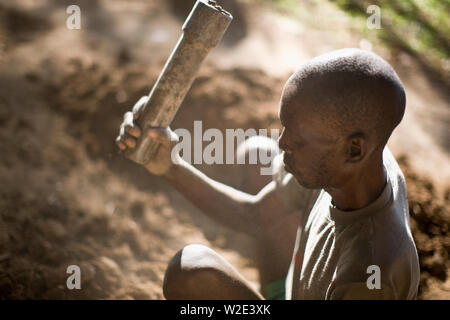Mature adult man sitting in the garden using tools. Stock Photo