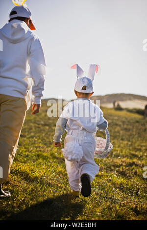 Two brothers in Easter costumes on an Easter egg hunt Stock Photo