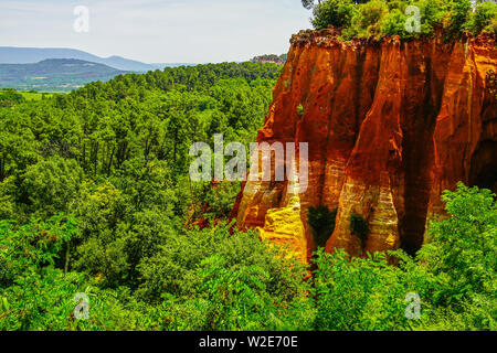 Intensive red cliff in the canyon landscape around village of Roussillon, Provence, France. Stock Photo