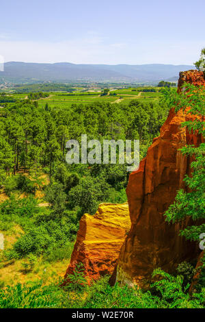 Intensive red cliff in the canyon landscape around village of Roussillon, Provence, France. Stock Photo