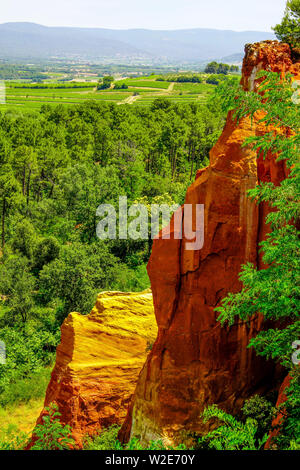 Intensive red cliff in the canyon landscape around village of Roussillon, Provence, France. Stock Photo