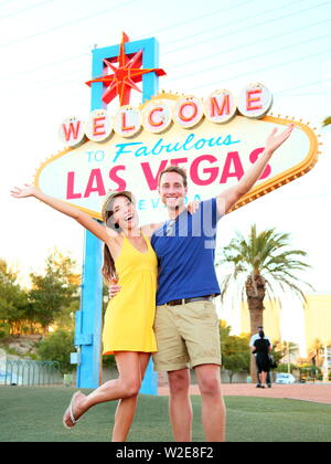Las Vegas Sign. Couple jumping having fun in front of Welcome to Fabulous Las Vegas sign. Happy people on holidays honeymoon on the Strip multiracial couple Caucasian man Asian woman Nevada USA. Stock Photo