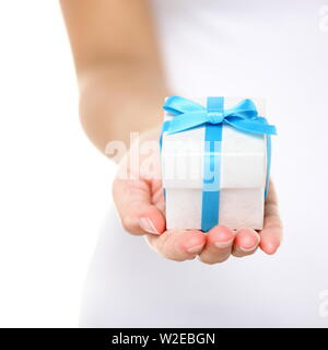 Gift box / present or christmas gift hand close up. Decorative gift box tied with a turquoise ribbon and bow carefully cupped in female hands as she gives a surprise present to a loved one. Isolated. Stock Photo