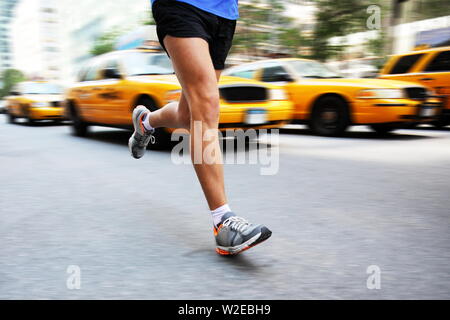 Running in New York City - man city runner jogging in street of Manhattan with yellow taxi caps cars and traffic. Urban lifestyle image of male jogger training downtown. Legs and running shoes. Stock Photo