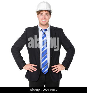 Engineer or architect business man in suit. Male businessman wearing white hard hat helmet smiling happy, proud and confident. Portrait of young male engineer in his 20s isolated on white background. Stock Photo