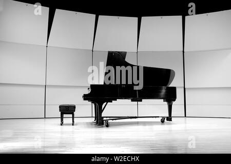 Black and white piano with bench on concert state for performance Stock Photo