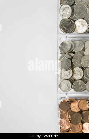 Isolated organized loose coin change on right side, white background, blank empty room space for copy or text on left. Financial organization money co