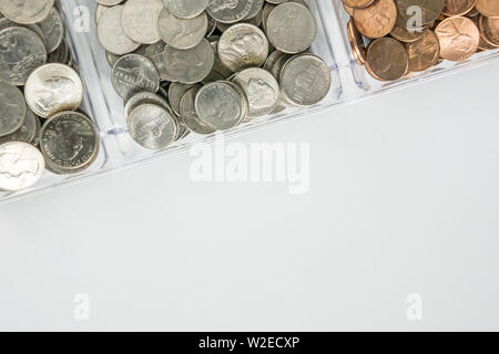 Isolated organized loose coin change on top side, white background, blank empty room space for copy or text on bottom. Financial organization money co