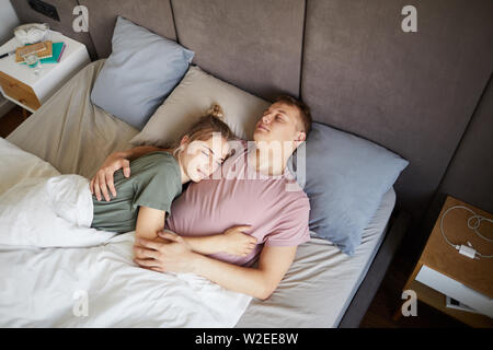 Young restful romantic couple sleeping together in bed after hard working day Stock Photo