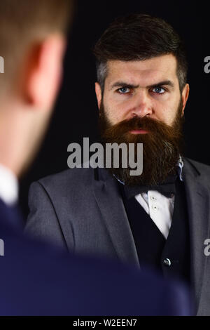 Businessmen, business partners meet on black background. Business partners on serious faces stand opposite each other. Eye contact concept. Businessme Stock Photo