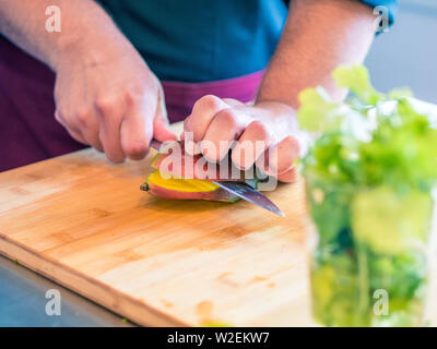 Close-up of man's hands preparing vegetables and fruit in modern cuisine Stock Photo