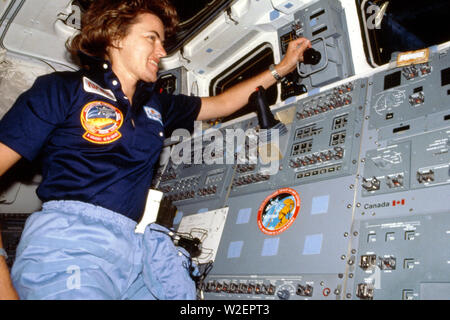 (17-24 June 1985) --- Astronaut Shannon W. Lucid monitors cargo bay activities with one of the satellite payloads aboard. Stock Photo