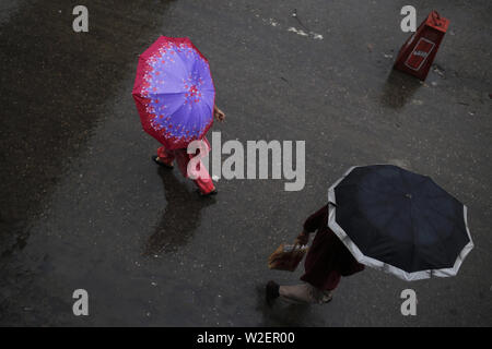 July 9, 2019 - Dhaka, bangladesh - People cover themselves under umbrellas during rainy weather in Dhaka. A tropical depression continued to bring heavy rainfalls to the country. (Credit Image: © MD Mehedi Hasan/ZUMA Wire) Stock Photo