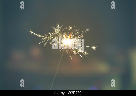 Sparks from hand cold fireworks dim background Stock Photo