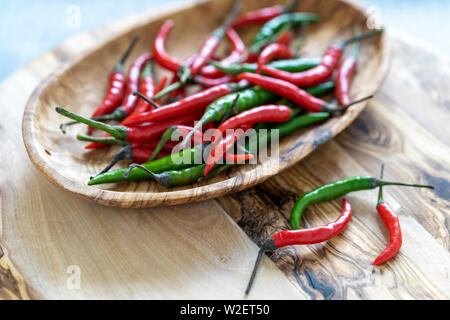 Red and green chilli's in a wooden bowl Stock Photo