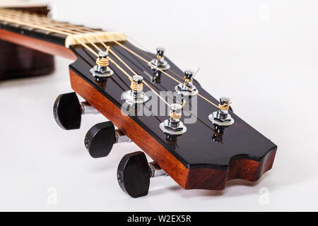Tuning pegs on wooden machine head of six strings guitar on white background Stock Photo