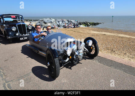 Classic Silver Morgan 3 wheeled Motor Car being driven on Seafront Promenade.