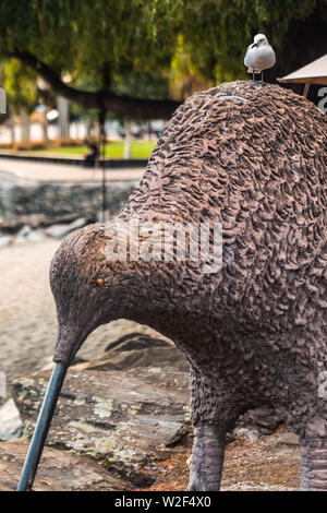 Gull sitting on kiwi statue near Lake Wakatipu in extreme sports capital Queenstown, New Zealand. Stock Photo